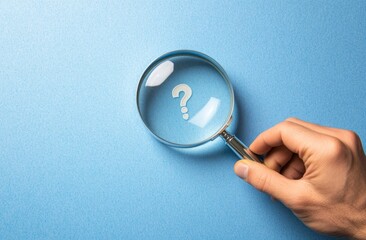 Hand Holding Magnifying Glass Over Question Mark on Blue Background