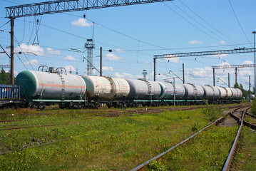 A Freight Train loaded with Tank Cars is traveling on the Tracks in Clear Weather Conditions
