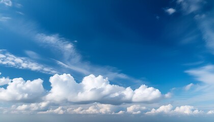 Obraz premium a vibrant blue sky adorned with fluffy white clouds gently drifting and casting soft shadows creating a serene and tranquil atmosphere