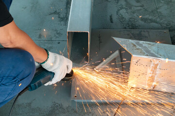 skilled worker grinding an iron pipe