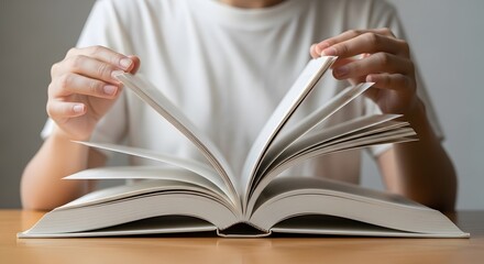 Hands hold an open book, a stack of literature, and a school textbook for education and study
