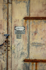 High voltage door in abandoned building with gritty urban textures