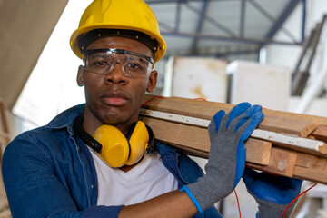 young african american male carpenter worker hold wooden plank at the carpentry workshop