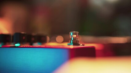 A guitarist engages an effect pedal footswitch with their foot.