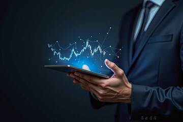 Businessman holding tablet with stock finance candlestick bar chart graph blue glowing floating