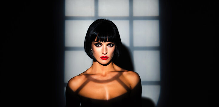 Beauty woman portrait in night shadows. Fashion portrait. Sensual brunette model face in night light. Beauty female face. Sexy beauty woman in studio dark light. Beauty portrait.