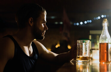 Alcohol addiction. Sad man in dark bar. Alcohol problem. Lonely man drinking at restaurant. Drinking alcohol. Depressed man with glass of alcohol. Hopeless alcoholic facing responsibility.