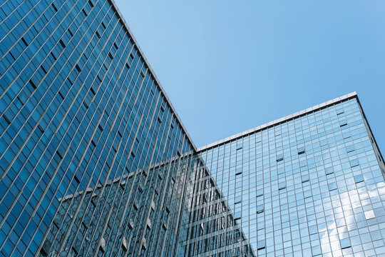 Low angle view of skyscraper with glass window and clear blue sky background for business and finance concept