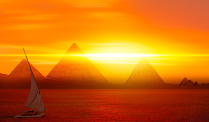 Fototapeta premium Beautiful Nile scenery with traditional Felluca sailing boat in the Nile to Giza pyramids at amazing sunset - Cairo, Egypt 