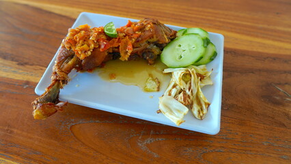 Delicious Indonesian Fried Chicken with Spicy Sauce, Cucumber, and Cabbage.