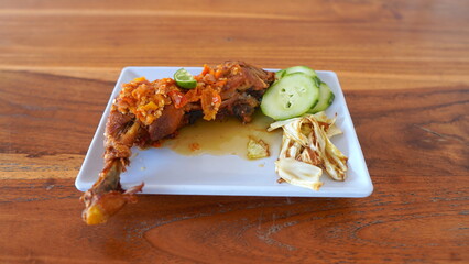 Delicious Indonesian Fried Chicken with Spicy Sauce, Cucumber, and Cabbage.