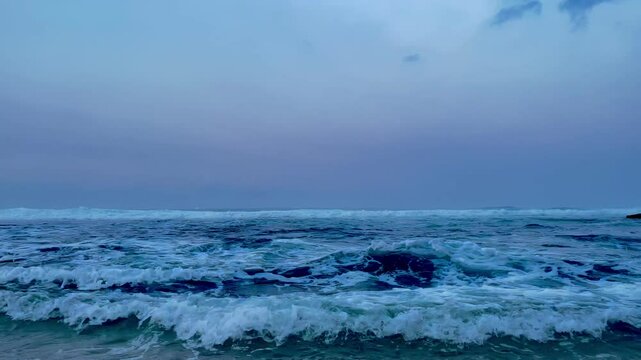 crashing waves against a cloudy sky background
