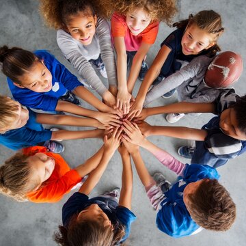 group of children giving a group cheer hands all in center overhead view dynamic composition sports team theme