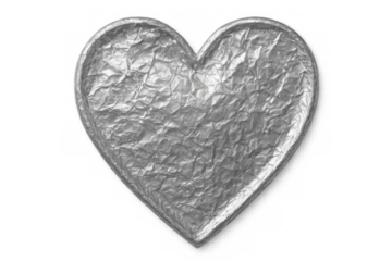 Crumpling silver metallic foil into heart-shaped form, symbolizing love against transparent backdrop