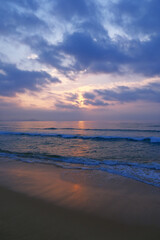 Obraz premium ocean waves and beach under a clouds sky at sunrise in Sanya, Hainan, China