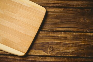 Chopping board on brown textured wooden flooring