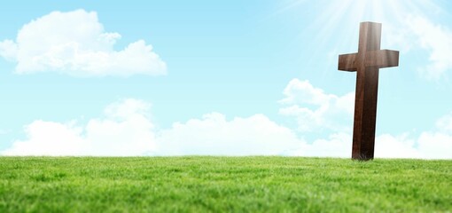 Wooden cross is standing on grassy hill under blue sky in flat design with sun rays