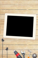 Tools and tablet on wooden background