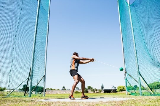 Man playing hammer throw against sky on sunny day - Powered by Adobe
