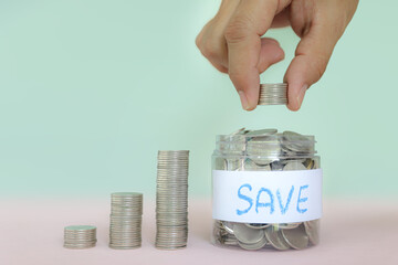 Hand and coin with piggy bank and pile coins stacked for growth real estate or money savings plan ideas and investment planning goal to growth and bank home loan or financial insurance.