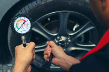 Mechanic holding car tire pressure to checking low tire pressures inflating tires to or refill or...