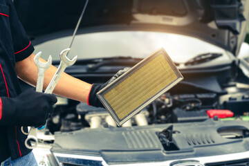 Auto mechanic holding car air conditioner filter for check and clean dirty or fix repair heat have engine problem or replace new change air filter of car care maintenance servicing concepts.