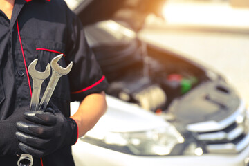 Auto mechanic holding the wrench for fix service repairing change spare part engine problem or insurance support or range of car check or training workshop and car care maintenance servicing.