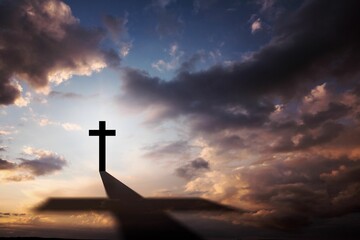 Obraz premium Flat illustration showing cross silhouette atop hill casting long shadow under sunset clouds