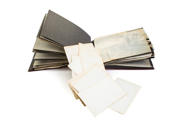 White photo backs stack, spilling out of a vintage photography album, isolated on white background,...