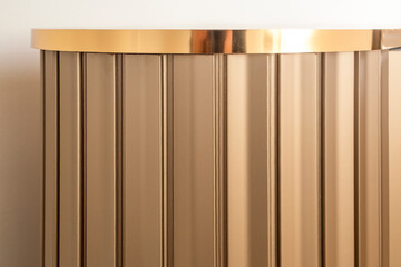 Striped wood cabinet with golden accents, soft focus close up, abstract countertop backdrop