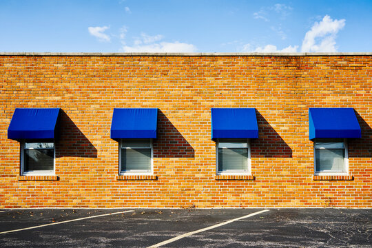 Four Windows with Klein Blue Awnings on a Brick Wall