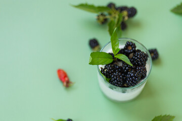 Summer yogurt with black blackberries and drops on glass