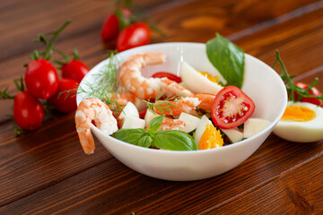 Delicious seafood salad with egg and basil close-up