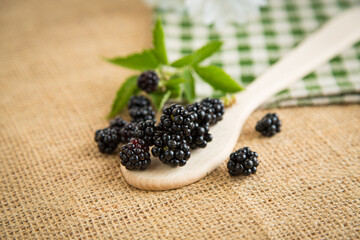 Close-up of ripe blackberries with leaves and spoon