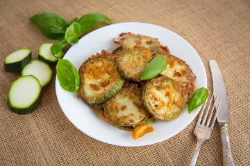 Crispy zucchini slices in sesame on a rustic table