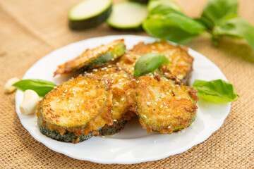 Summer vegetable appetizer of fried zucchini and sesame seeds on a rustic table