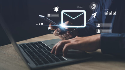 Email marketing concept. Businessman uses mobile phone and laptop to manage customer messages and campaigns with email tools and digital communication icons.