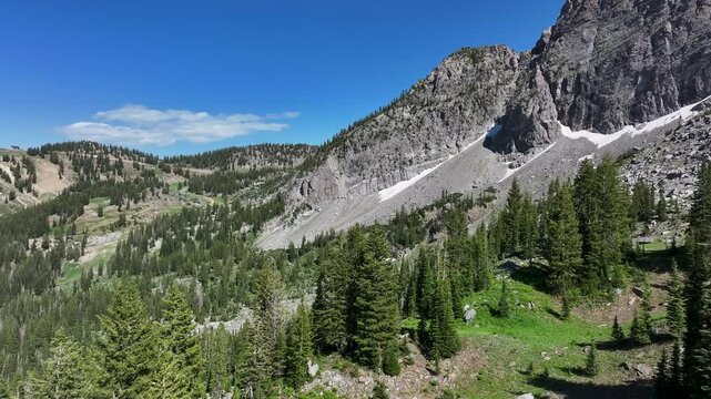 Aerial Albion Basin Alta Utah mountain trail forest fast. Steep alpine granite mountain, valley, hiking, trails, forest, lake. Vacation destination. Nature landscape forests. Rugged Rocky Mountains.