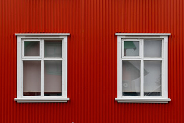 Fototapeta premium View of white windows on a red house.