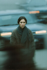 Woman in a Coat Standing in Front of Traffic