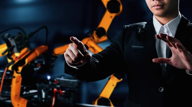 Engineer use cybernated robotic software to control industry robot arm in factory . Automation manufacturing process controlled by specialist using IOT software connected to internet network .