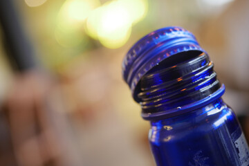 Blue bottle with a silver cap resting on a table