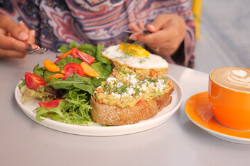 Delicious brunch with avocado toast and fresh salad at cafe