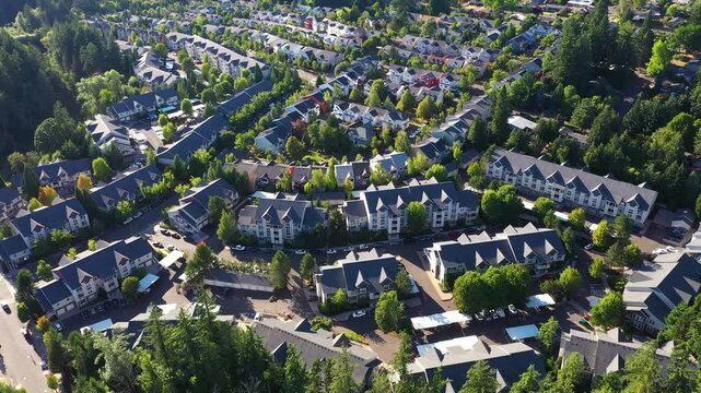 4k aerial drone footage of a beautiful residential homes, apartment complexes in Cedar Mill, Portland, OR, captured at sunset. Showing green courtyards,  parking lots, streets and housing buildings