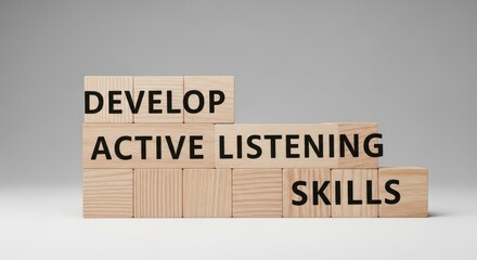 Wooden blocks with words develop active listening skills placed on grey background representing personal development training and communication