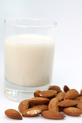 Healthy almond milk in drinking glass with roasted almond on white background.Healthy,Food and drink concept.