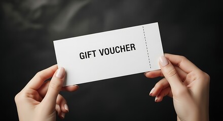 Elegant hands holding a pristine white gift voucher against a dark background