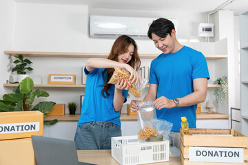Donation Process. Volunteers packing food items for charity in a community center.