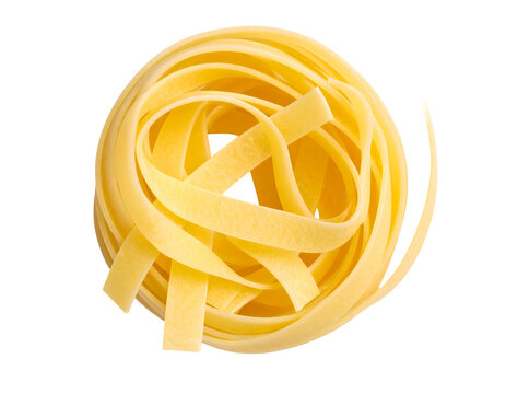 Isolated tagliatelle pasta nest on black