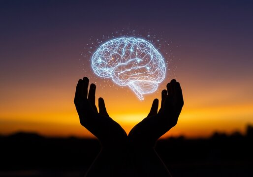 Glowing Brain Held by Silhouetted Hands Against a Sunset Sky
